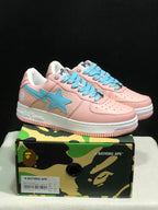 Pair of pink and light-blue Bape Sta low-top sneakers displayed on a camouflage Bape-branded shoe box; the box label visibly shows EU 41, US 8, UK 7, and CM 26.