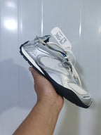 Side view of the silver Balenciaga Radar sneaker showing the mesh construction, contrasting overlays, lace fastening, and black treaded outsole.