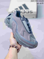 Three-quarter side view of the gray sneaker showing the layered upper, lace-up design, sculpted sole, and ADIPRENE+ marking.
