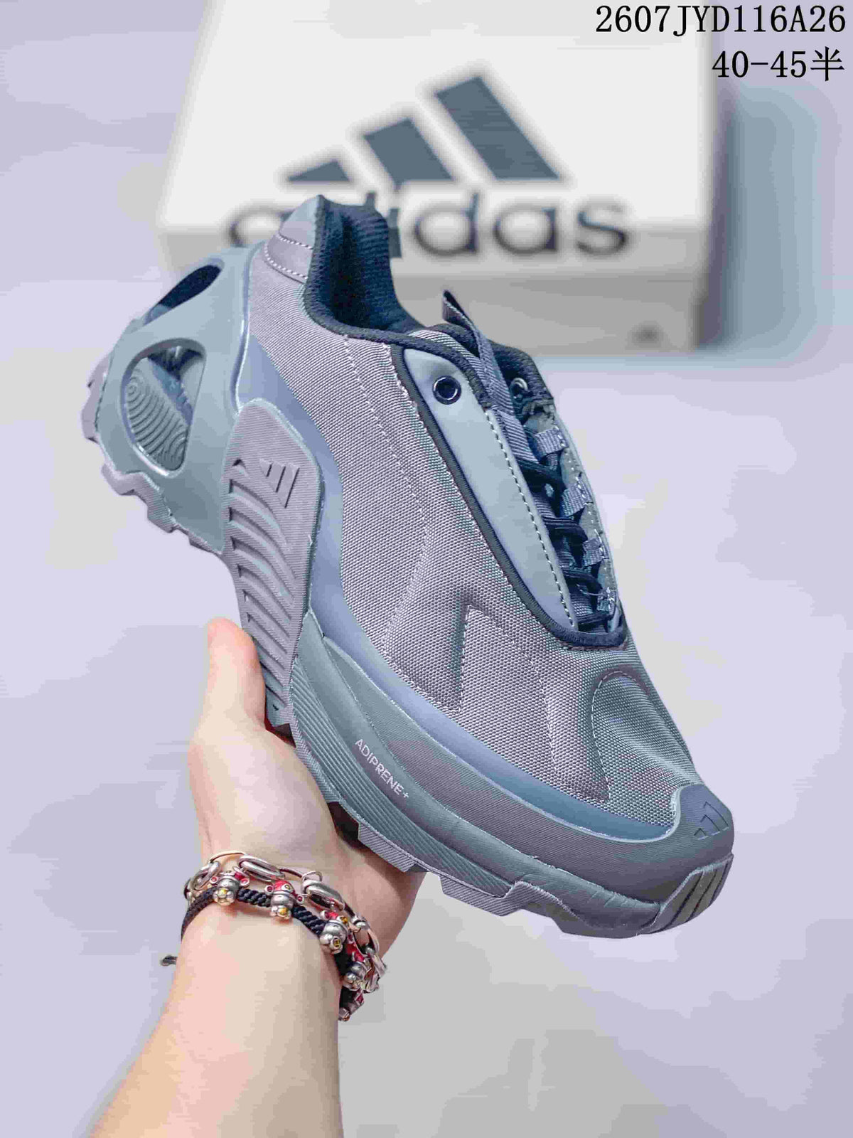Three-quarter side view of the gray sneaker showing the layered upper, lace-up design, sculpted sole, and ADIPRENE+ marking.