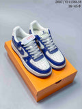 Blue and white low-top sneakers with contrasting overlays displayed on an orange shoe box.