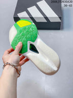 Close-up of the running shoe outsole, showing green tread, a yellow heel section, and a central cutout.