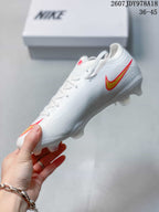 Side profile of the white Nike soccer cleat showing the gold and red Swoosh and molded outsole studs.