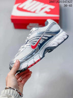 Side profile of a Nike Air Max Moto 2K sneaker showing the mesh upper, layered panels, and red accent details.
