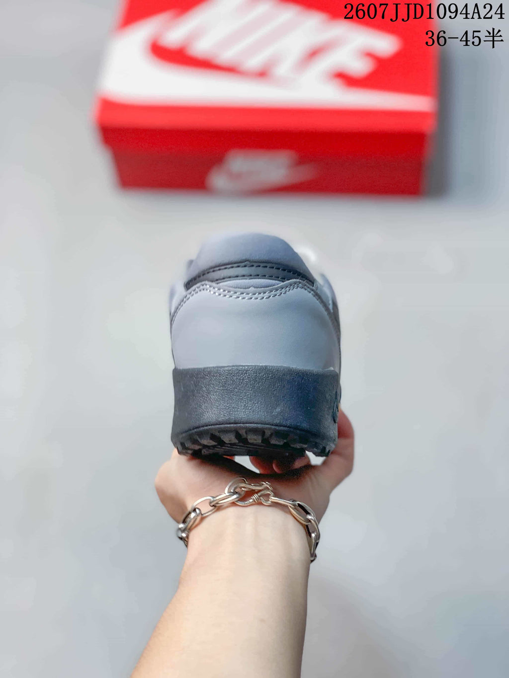 Rear view of the gray sneaker showing the padded heel and dark textured outsole edge.
