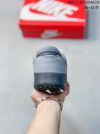 Rear view of the gray sneaker showing the padded heel and dark textured outsole edge.