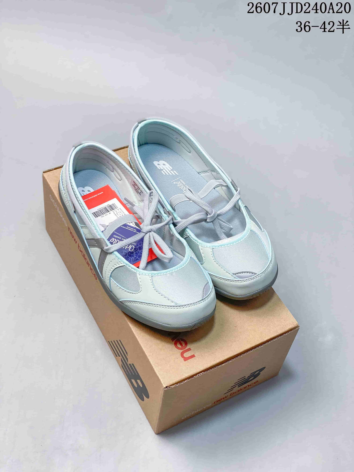 Pair of light blue and gray New Balance Flat Breeze shoes displayed on a New Balance box.