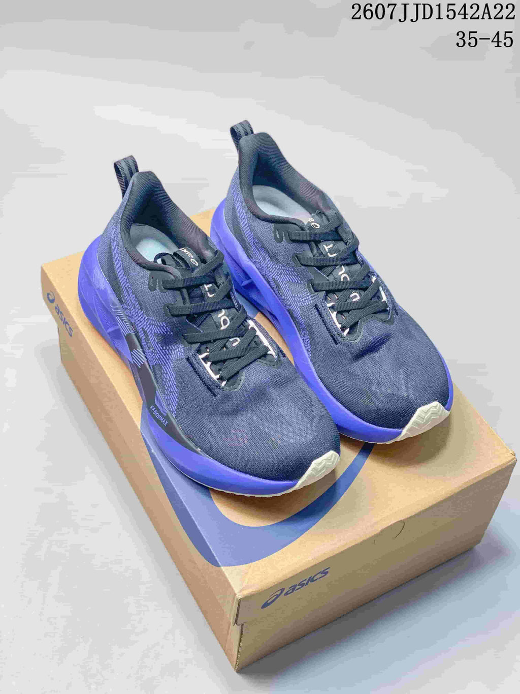 Pair of dark navy and purple ASICS GEL-NOVABLAST 5 LE running shoes displayed on an ASICS shoe box.