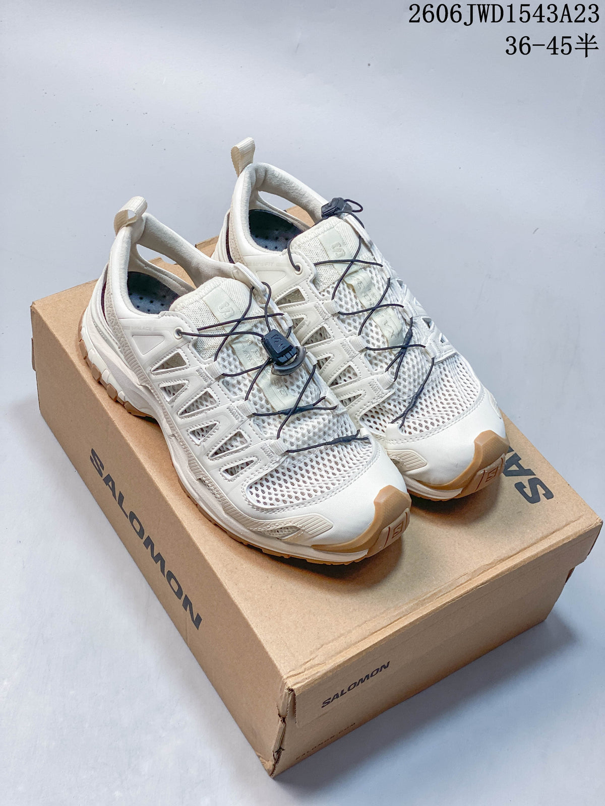Pair of ivory Salomon XA Pro 3D Amphib low-top sneakers on a shoe box