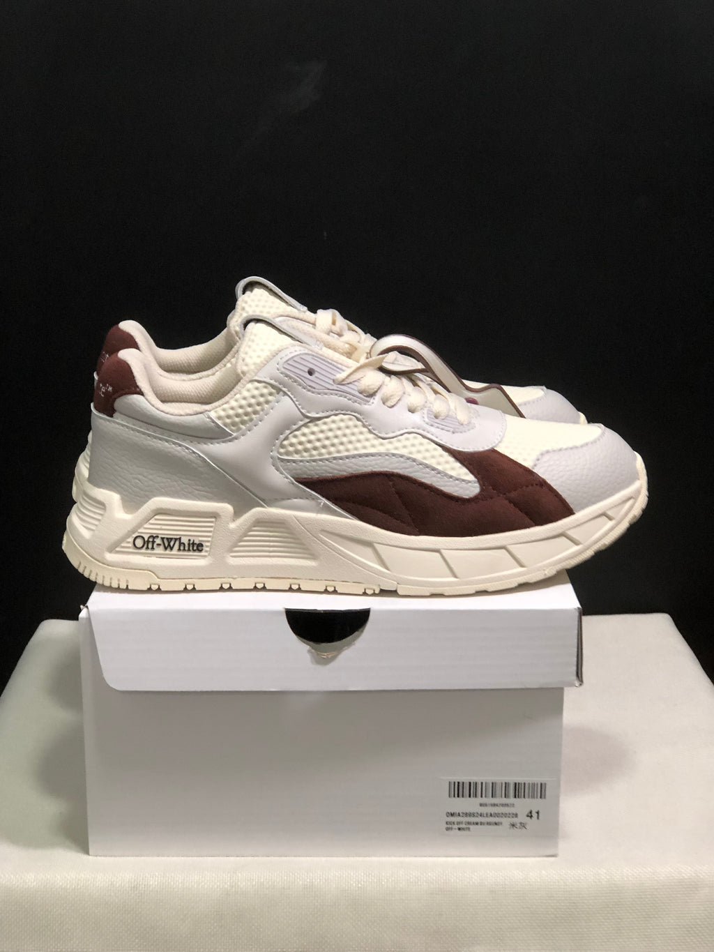 Side view of a white and brown sneaker pair with visible OFF-WHITE branding on the side sole area.