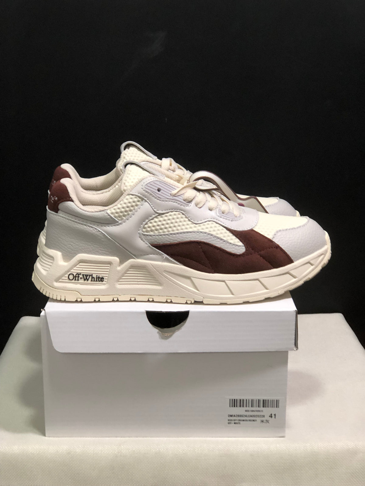 Side view of a white and brown sneaker pair with visible OFF-WHITE branding on the side sole area.