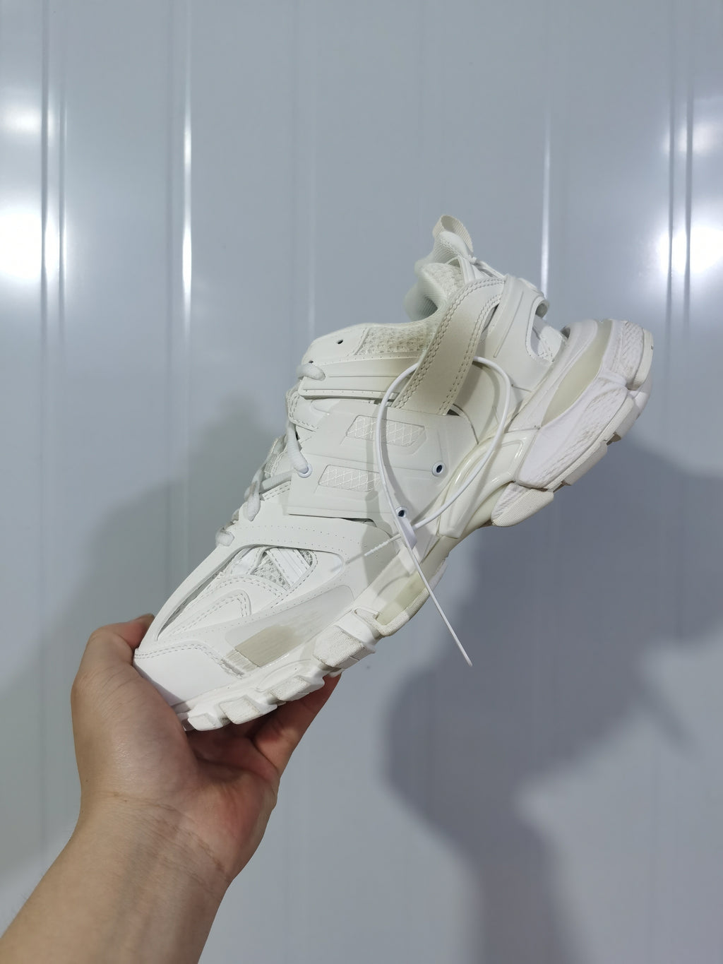 Rear and outsole view of the white Balenciaga Track sneaker, showing its layered construction and chunky segmented sole.