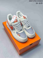 Pair of white, grey, and red low-top sneakers displayed on an orange shoebox; overlay text shows style code 2607JYD1153A23 and size range 36–45.5.