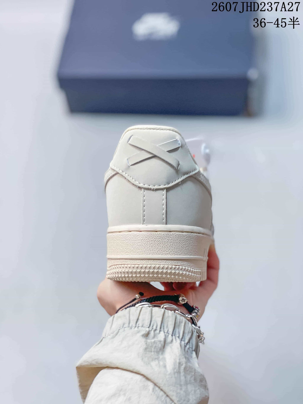 Rear view of the white and cream low-top sneaker showing the heel structure and outsole.