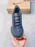Top view showing the lace-up design, dark gray mesh-textured upper, and orange toe accent.