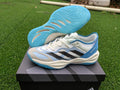 Adidas Adizero white and blue shoes shown on a box with the blue outsole visible.