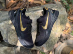 Top-down view of the black and gold sneaker pair showing the lacing system and side branding.