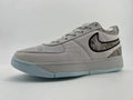 Gray Nike Book 1 sneaker with patterned panels and pale blue outsole, angled side view