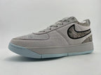 Gray Nike Book 1 sneaker with patterned panels and pale blue outsole, angled side view