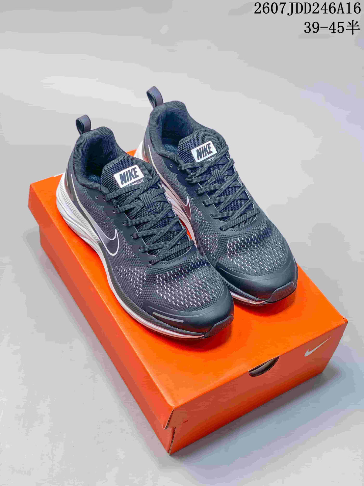 Pair of dark gray and white-accented running sneakers displayed on an orange shoe box.