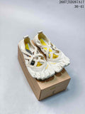 Pair of off-white Vibram five-finger training shoes displayed on a shoebox, showing the individual toe compartments and yellow interior accents.