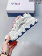 Side view of the white and gray low-top sneaker showing layered panels, sculpted sole sections, and dark blue outsole details.