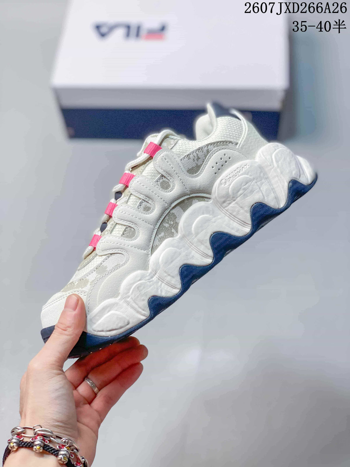 Side view of the white and gray low-top sneaker showing layered panels, sculpted sole sections, and dark blue outsole details.