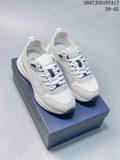 Pair of white and gray Dior B25 Runner sneakers displayed on a dark presentation box.