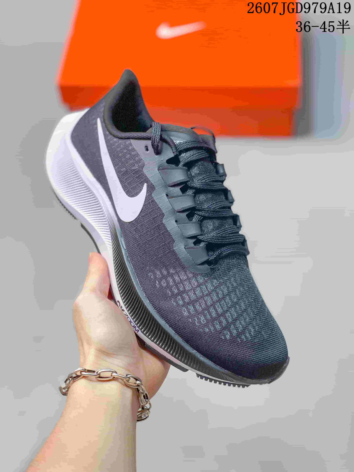 Angled front-side view of the dark Nike Pegasus 37 sneaker showing the lace system, textured upper, side branding, and contrasting white midsole.