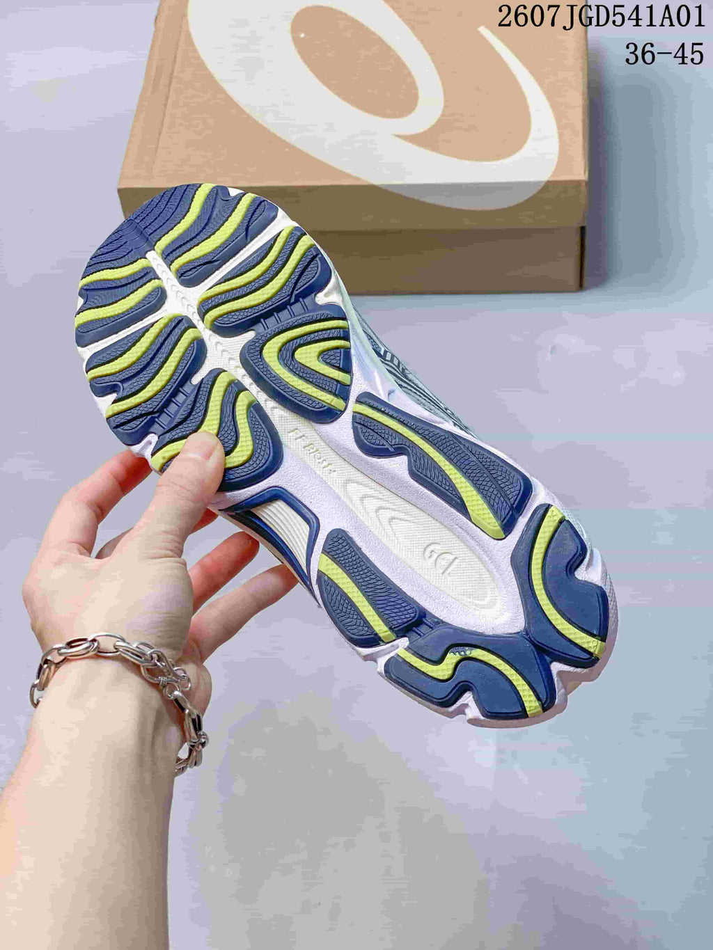 Close-up of the sneaker outsole with navy and yellow-green tread details
