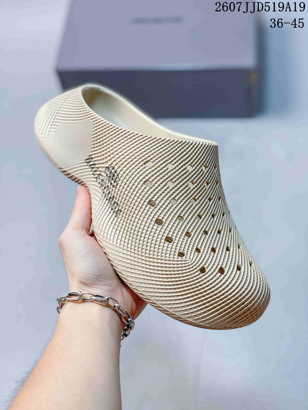 Cream perforated slip-on clog shown from an angled side view, with a thick textured sole.