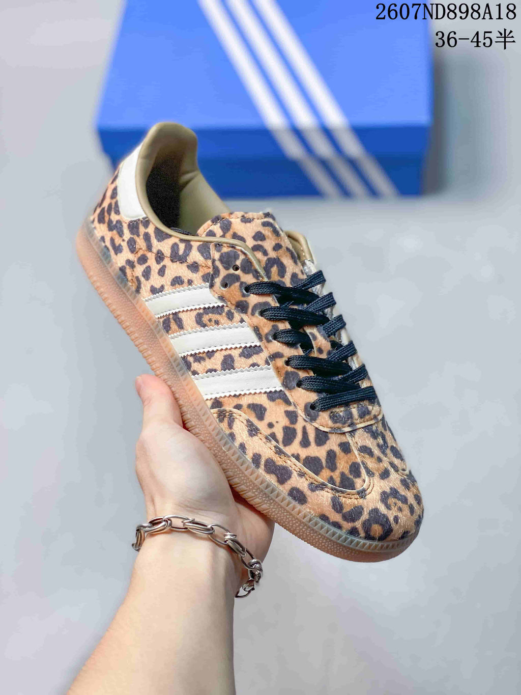 Angled side view of the leopard-print Adidas Samba OG sneaker with contrasting white stripes and gum outsole.