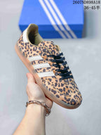 Angled side view of the leopard-print Adidas Samba OG sneaker with contrasting white stripes and gum outsole.