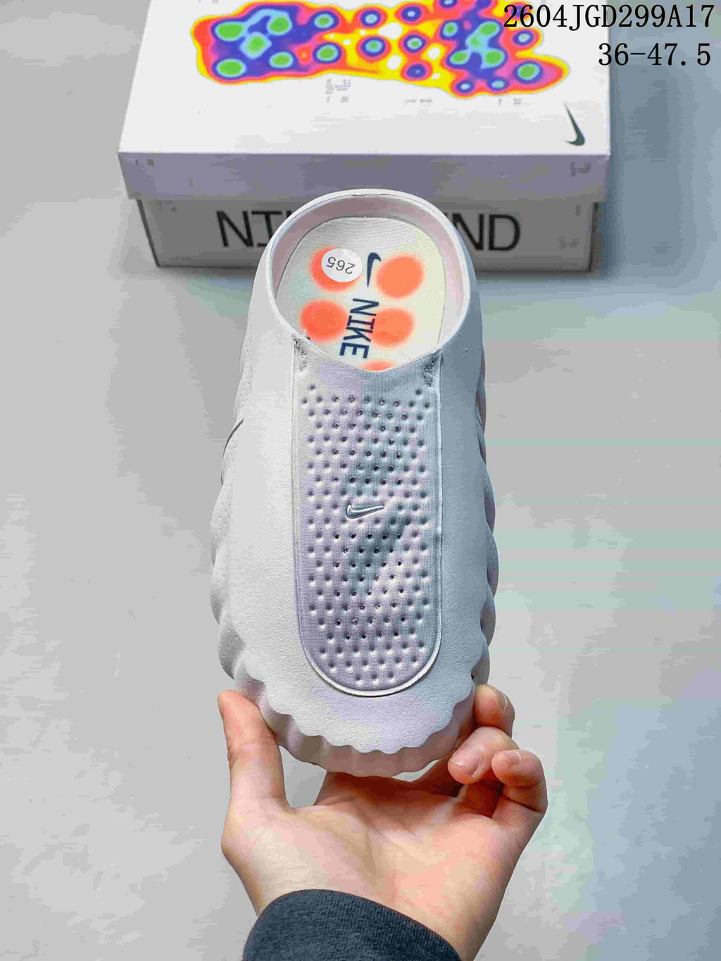 Top view of the white Nike Mind slide showing the perforated footbed, Nike Swoosh and orange insole details.