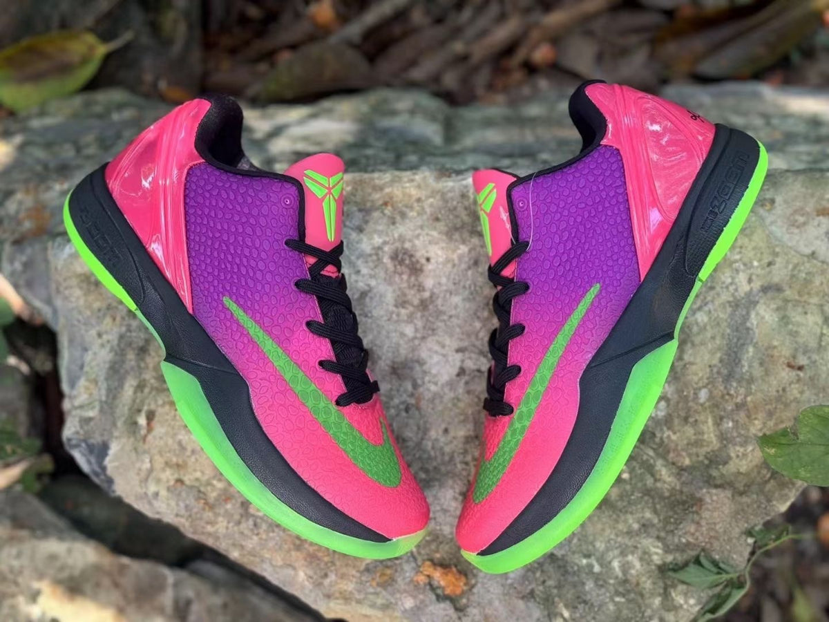 Pair of pink and purple shoes with black laces and green accents