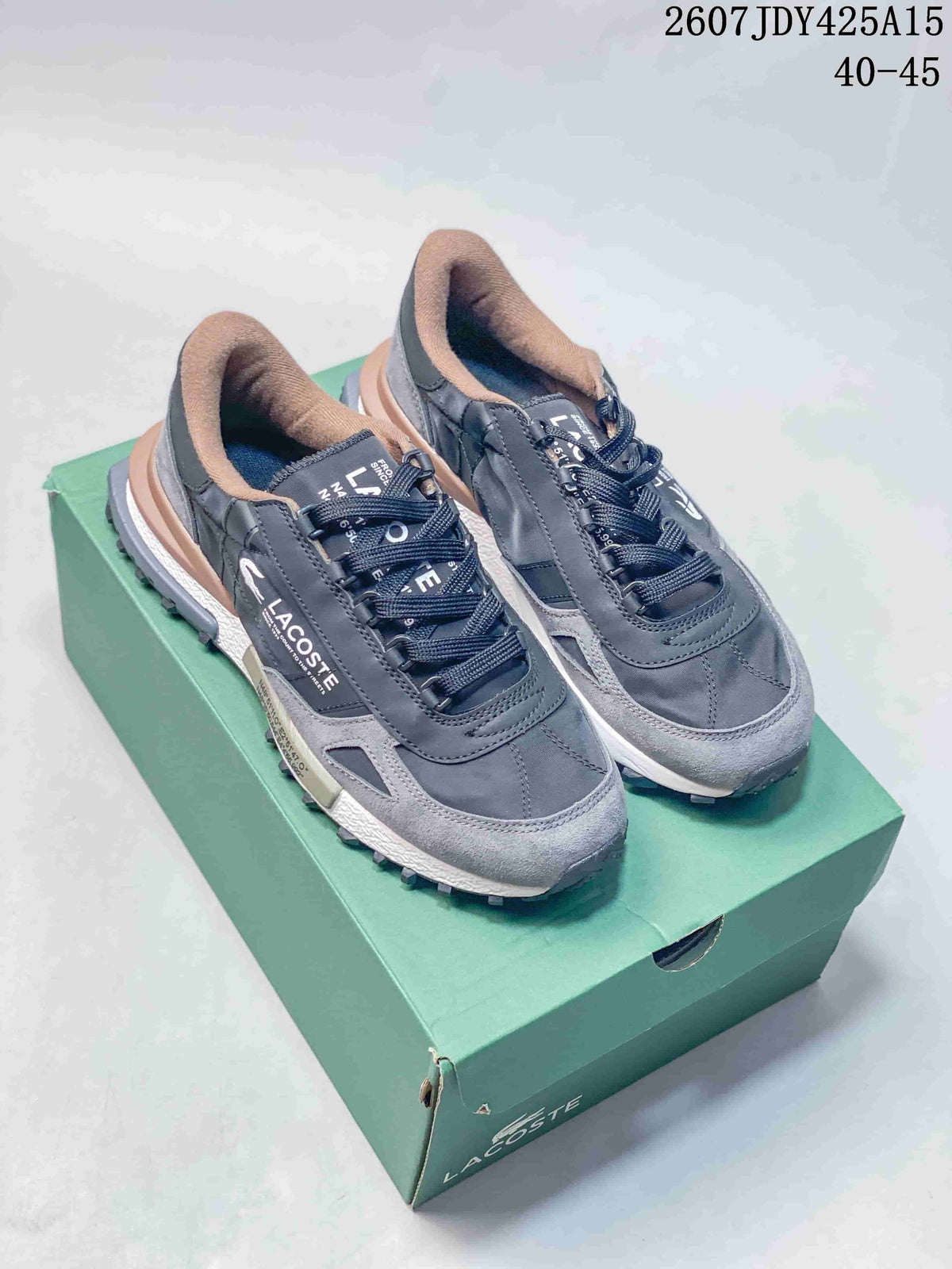 Black and gray Lacoste sneakers displayed on a green shoe box, with the model code and size range visible at the top.