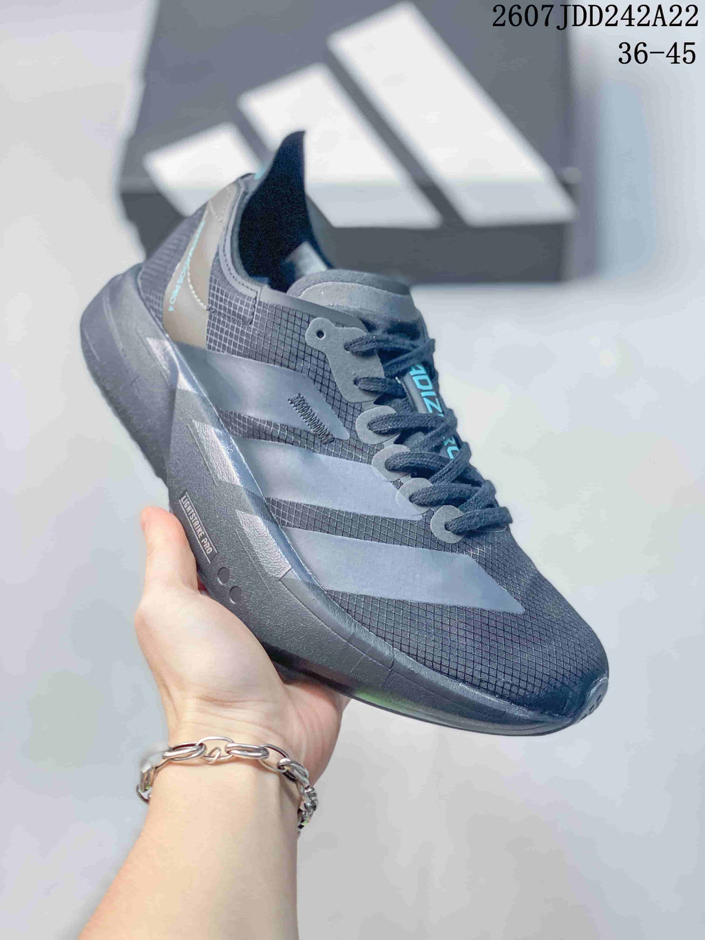 Angled side view showing the dark gray upper, layered side panels, lace-up construction, and black outsole.