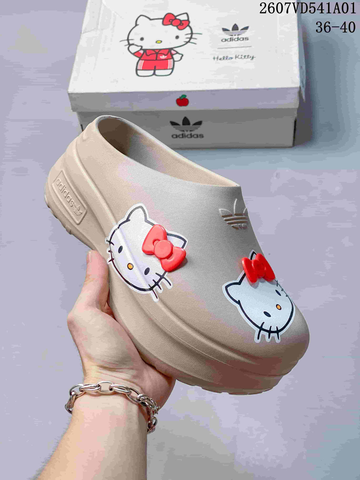 Angled view of the beige mule clog with Hello Kitty graphics and red bow accents