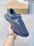 Angled side view of the dark navy sneaker showing the mesh-like upper, lace system and segmented sole.