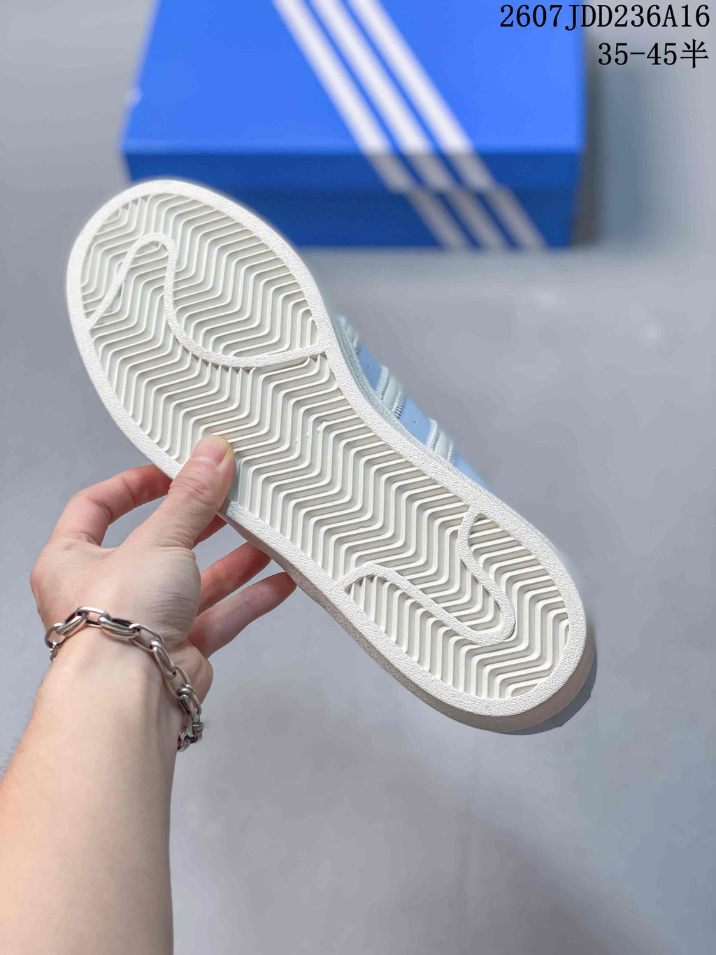 Close-up of the white outsole showing a zigzag tread pattern and shell-toe-inspired shape.