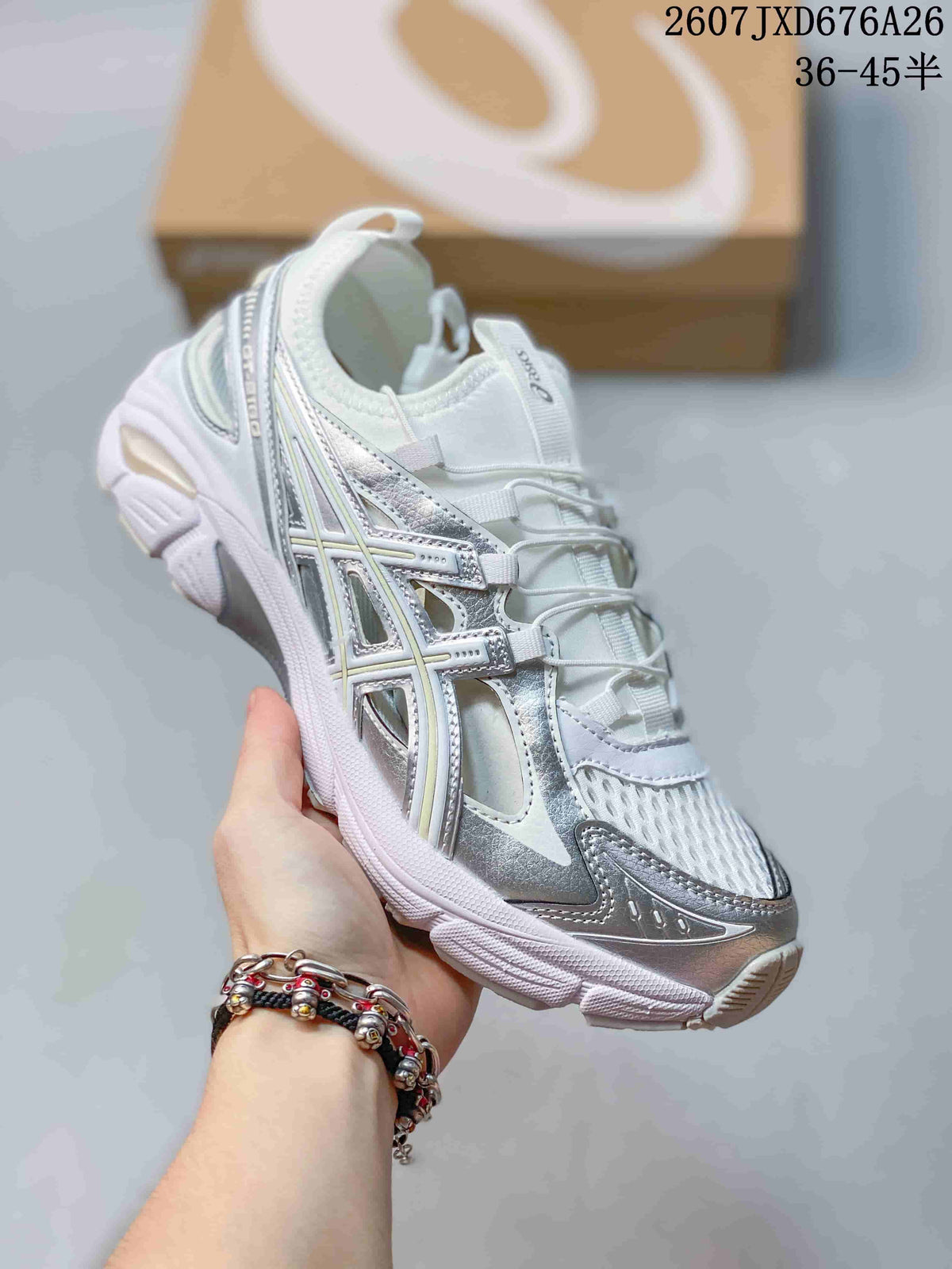 Angled side view of the white and silver ASICS sneaker showing the layered upper, metallic-look overlays, and segmented sole.