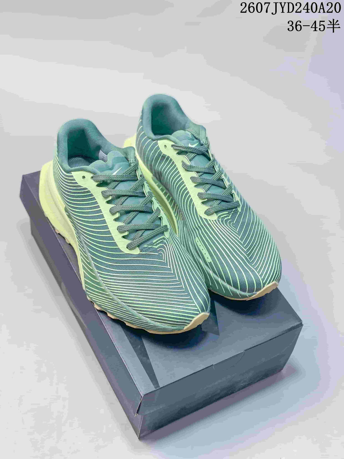 Pair of green and pale lime Nike ACG Ultrafly Trail sneakers displayed on a box; style code and size range text are visible above.