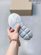 Underside view of the white segmented outsole with textured tread and visible On details.