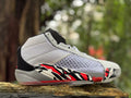 Side view of a white Jordan XXXVIII shoe with black and red geometric accents.