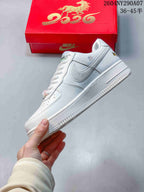 Side view of a white low-top sneaker with a silver Swoosh-style panel, white midsole, and embroidered upper details.