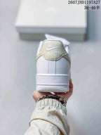 Rear view of the white sneaker showing the padded collar, heel stitching, pale beige accent, and Air branding.
