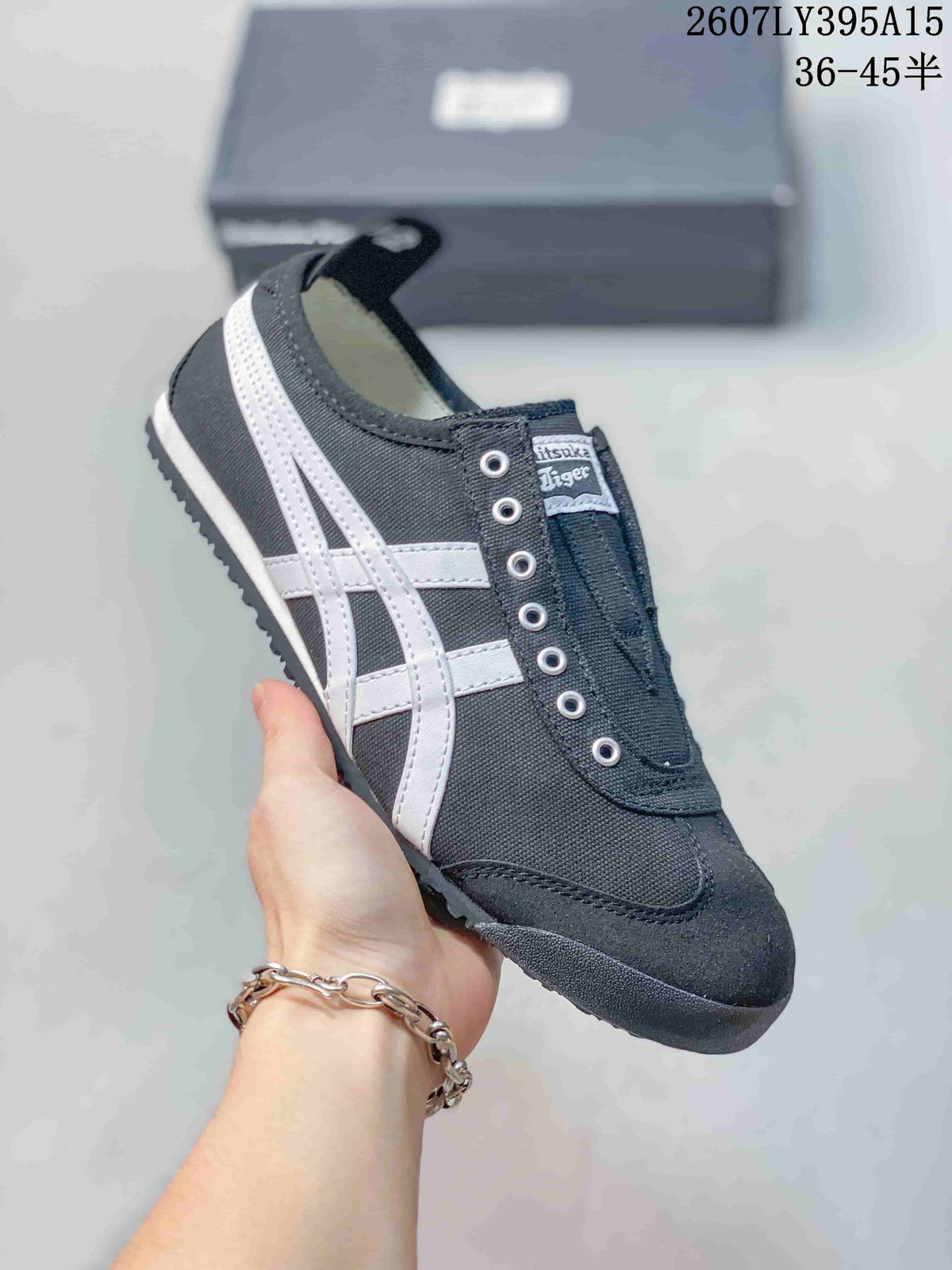 Side view of the black and white Onitsuka Tiger sneaker showing stitched overlays, side stripes, metal eyelets and textured outsole.