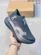 Angled side view of the dark gray slip-on sneaker with white branding and contrasting side panel.