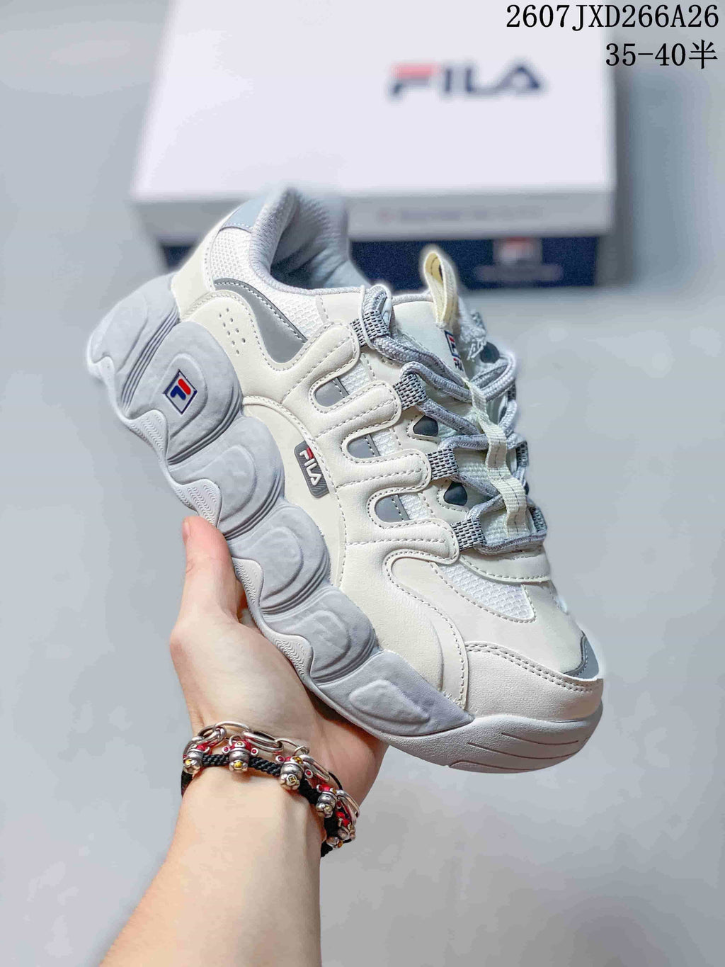 Angled side view of the white and gray FILA Croissant sneaker showing its layered upper and sculpted sole.