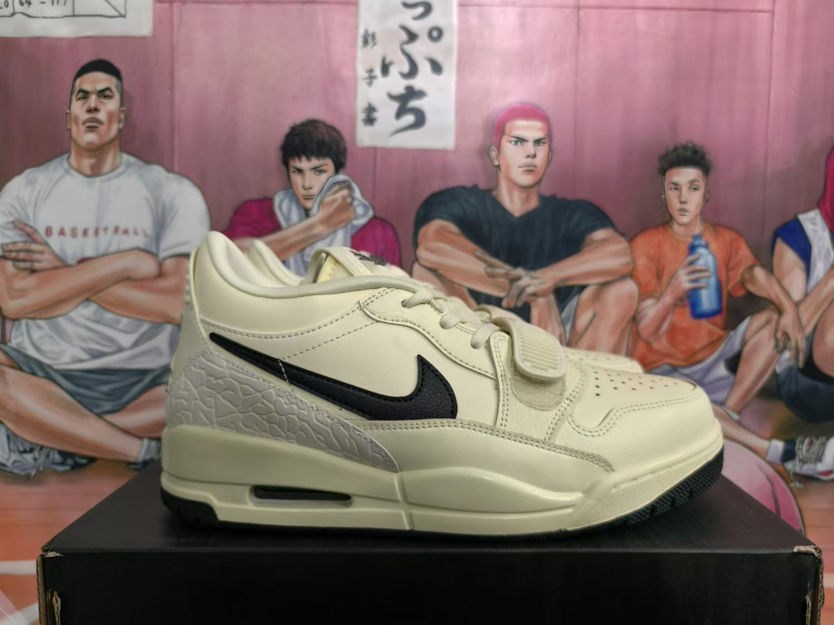 Side view of cream-and-black low-top sneakers with a midfoot strap and textured heel panel